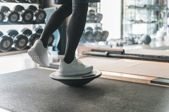 スーツジムでバランスボードに乗って体幹トレーニングする男性の足元
