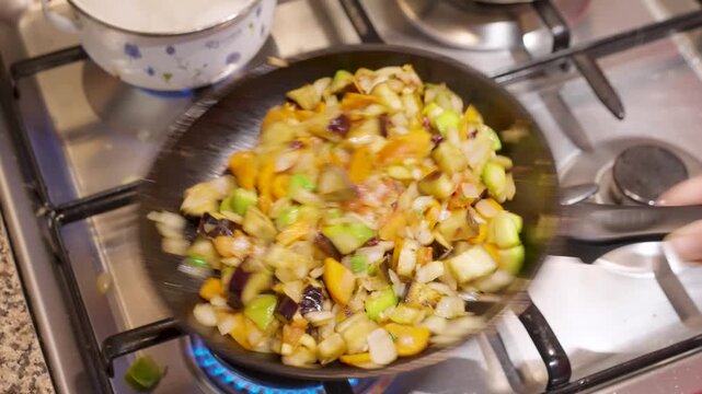 Sart&eacute;n con verduras cortadas en cuadraditos siendo salteadas. Salteado de verduras. Cocinando. Cocina. Cocinero. Cocinero. Footage de Cocina. Dieta. Comida saludable, vegetariana. 