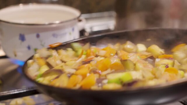 Sart&eacute;n con verduras cortadas en cuadraditos siendo salteadas. Salteado de verduras. Cocinando. Cocina. Cocinero. Cocinero. Footage de Cocina. Dieta. Comida saludable, vegetariana. 