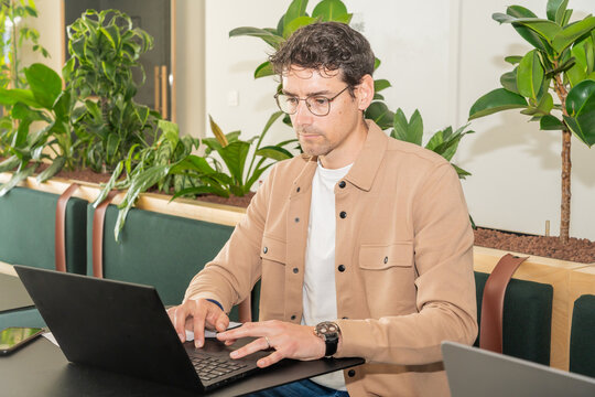 Flash Portrait Of A Man Typing On Laptop In Office