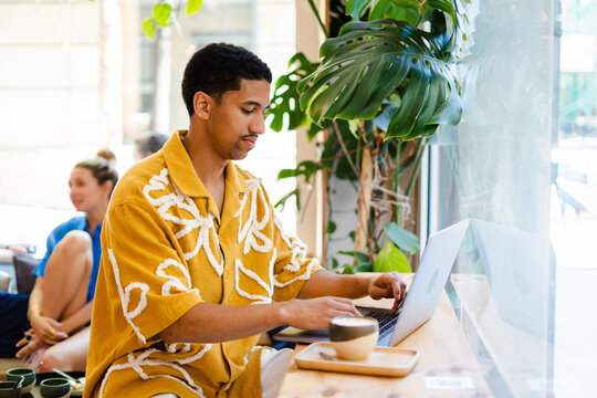 Male Working On Laptop From A Cafe
