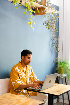Man Working On Laptop From A Cafe