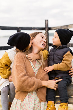 Mother With Children On Wooden Deck