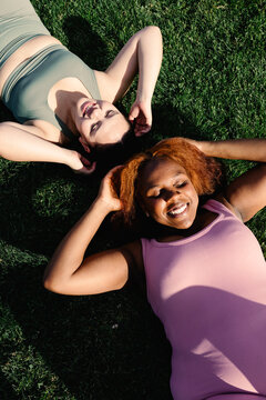 Plus-size friends do abdominal strengthening exercises outdoors