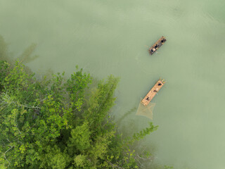 Woman carrying good on her head while walking across a wooden bridge.