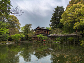 Fototapeta premium Traditional Japanese structure set among a beautiful Japanese garden and pond on a rainy day