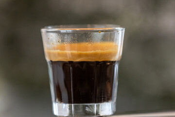 To prepare an espresso, finely ground coffee is used to brew a small, concentrated shot of coffee. The process begins by tamping the coffee grounds tightly into the portafilter. Hot water, under high 