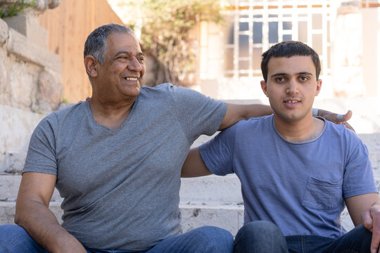 Father and Teenager Son Sitting on Steps Outdoors
