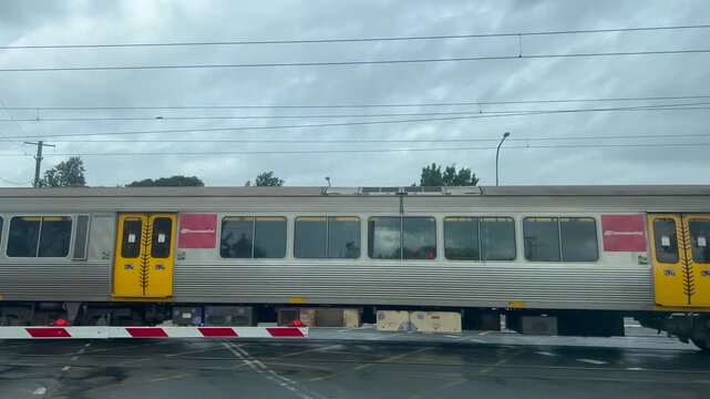Queensland Rail (QR) trains pass railway traffic light and barrier.It owned by Queensland Government,owning and maintaining approximately 6,600 km (4,101&nbsp;mi) of infrastructure