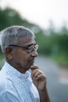 Portrait and facial expression of an Indian aged man at outdoors