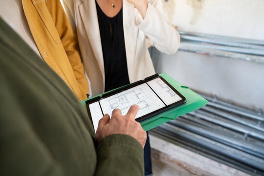 Architect Showing House Plan On Tablet To Clients