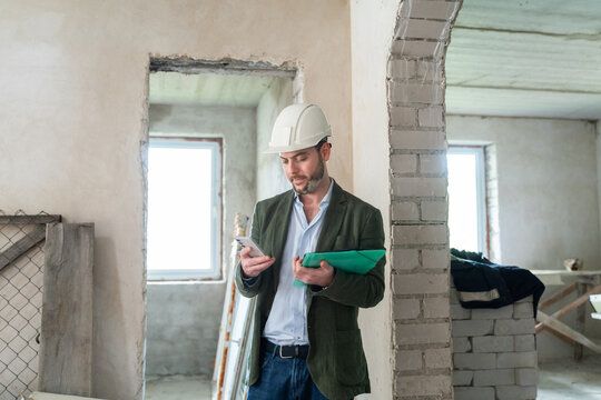 Architect Using Cellphone At Construction Site