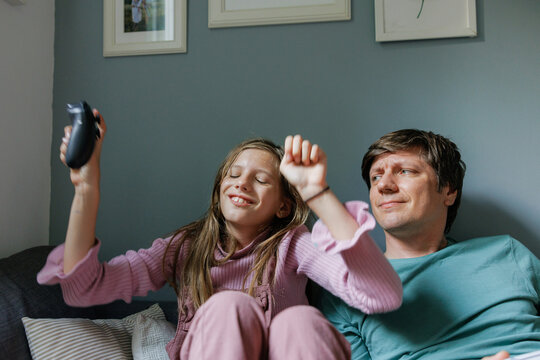 Father and daughter paying video games at home