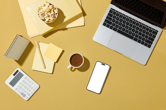 Top view of the table with a laptop, calculator, and mobile