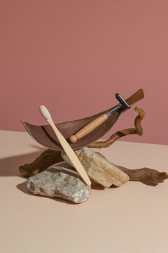 Wooden Toothbrushes Displayed on Natural Elements with Pink Back