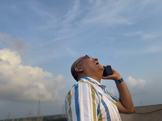 A middle aged man talking with smartphone looking very happy