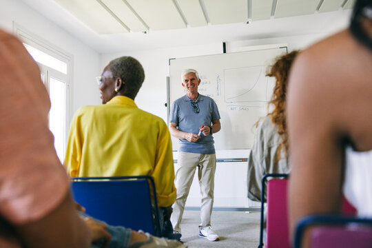 Business presentation by senior man professional to diverse team