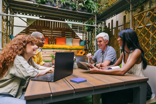 Group of Diverse Colleagues Collaborating in Cozy Patio Workspace
