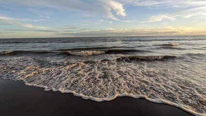Calm Waves on a Sandy Beach at Sunset