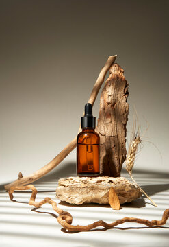 Amber Glass Dropper Bottle With Natural Elements on a White Background