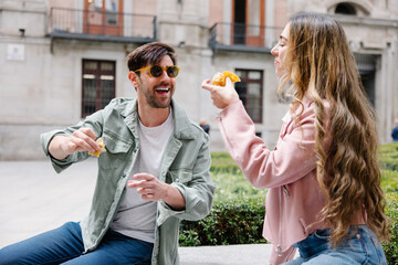 Playful interaction between friends sharing food outdoors