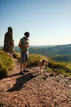 Retired Man Enjoying Hiking Trip with Dog at the Mountain in summer