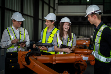 Factory engineers inspect on machine. Confident team mature businessman with laptop standing by robotic arm in industry businessman inspect at height technology for produce the electronic part device.