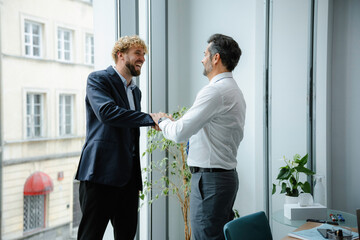 Men congratulate each other in the office