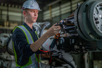 male engineer workers maintenance automatic robotic arm machine in a factory. worker checking and repairing automatic robot hand machine. technician worker check for repair factory machine.