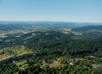 A beautiful view of a forest with a house in the distance