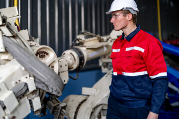 Fototapeta premium male engineer workers maintenance automatic robotic arm machine in a factory. worker checking and repairing automatic robot hand machine. technician worker check for repair factory machine.