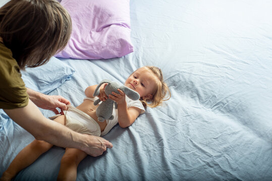 Father puts a fabric nappy for a baby