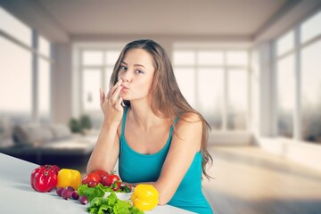 Happy young woman eating at kitchen at home