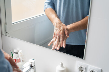 Hand washing with soap in bathroom