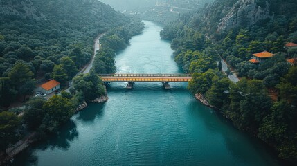 Fototapeta premium Aerial View of Bridge Over River in a Lush Green Valley