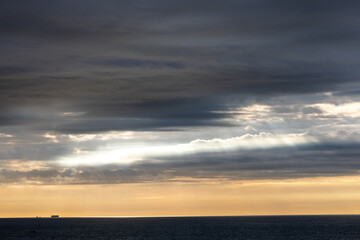 Captivating sunrise over the ocean, featuring dramatic clouds, sunlight rays, and a stunning horizon view