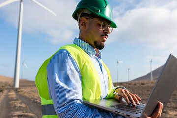 Engineer works with a laptop reviewing technical data from a turbine