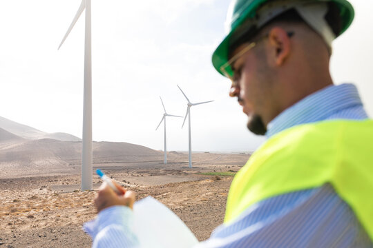 Wind turbines stand out in the landscape, in the foreground a worker
