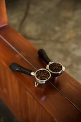 Top view of coffee beans in a porta filter or portable coffee filter holder and ground coffee for a coffee maker