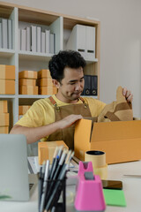 An entrepreneur is checking products in the system and packing them up to ship to buyers from his online business, store, package, parcel, inventory, woking in a self-established business