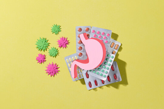 Stomach Health Concept with Pills, virus on Yellow Background