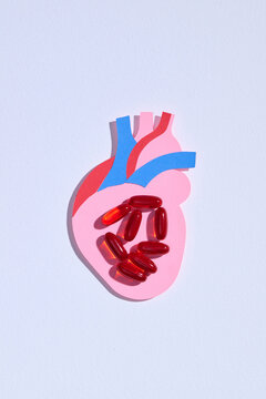 Paper Heart with Pills on White Background