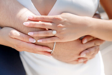 Man hugging his woman, hands close-up with ring and big gemstone. Concept of love and care between man and woman. Jewelry in the form of ring with gemstone