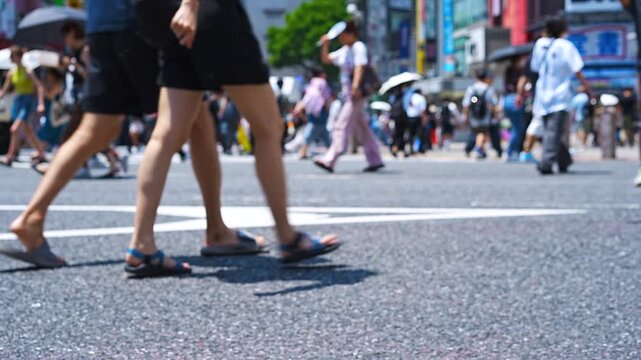 Large crowds of people walking Shibuya scramble crossing Tokyo at summer [low angle]