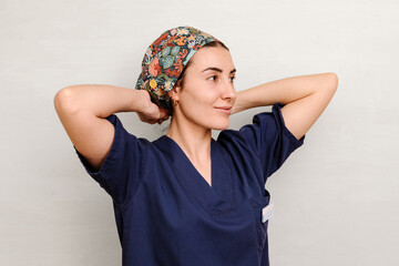 Medical professional in scrub adjusting colorful floral headscarf