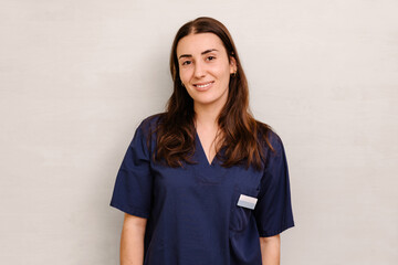 Friendly female healthcare worker in blue uniform posing at work