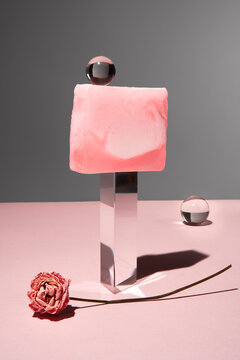Abstract still life with pink marbled soap on glass prism with flower.