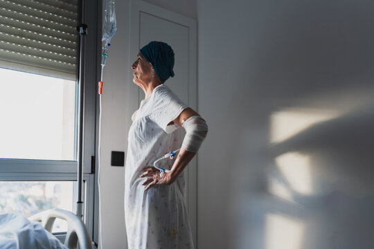 Senior female patient looking through window at hospital