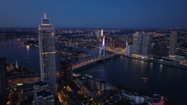 Lively charm of Rotterdam at twilight from above, highlighting the glowing erasmus bridge, contemporary buildings, and peaceful canals