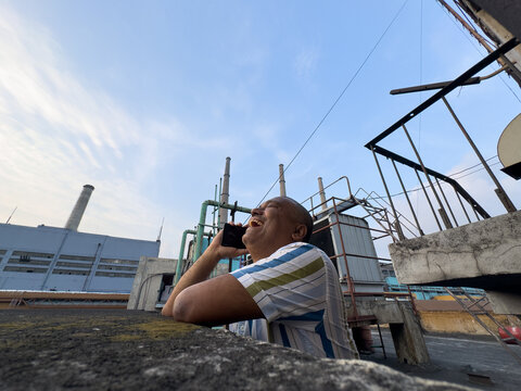 A middle aged Indian man speaking in smartphone